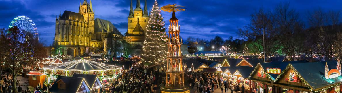 Christmassy illuminated market in the evening with pyramid, Christmas tree, St. Mary's Cathedral and Church of St. Severus